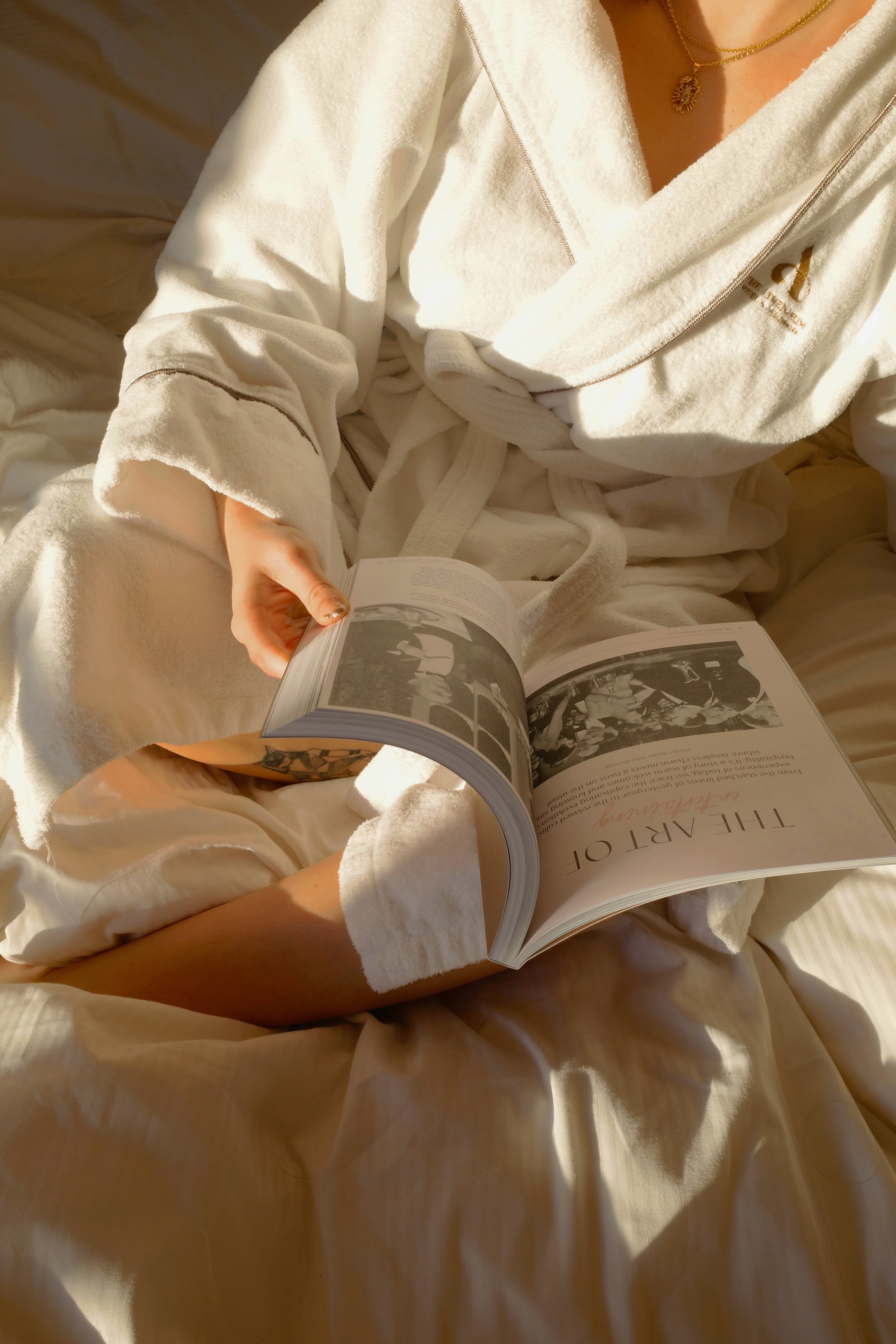 Guest in Athenaeum robe reading in bed