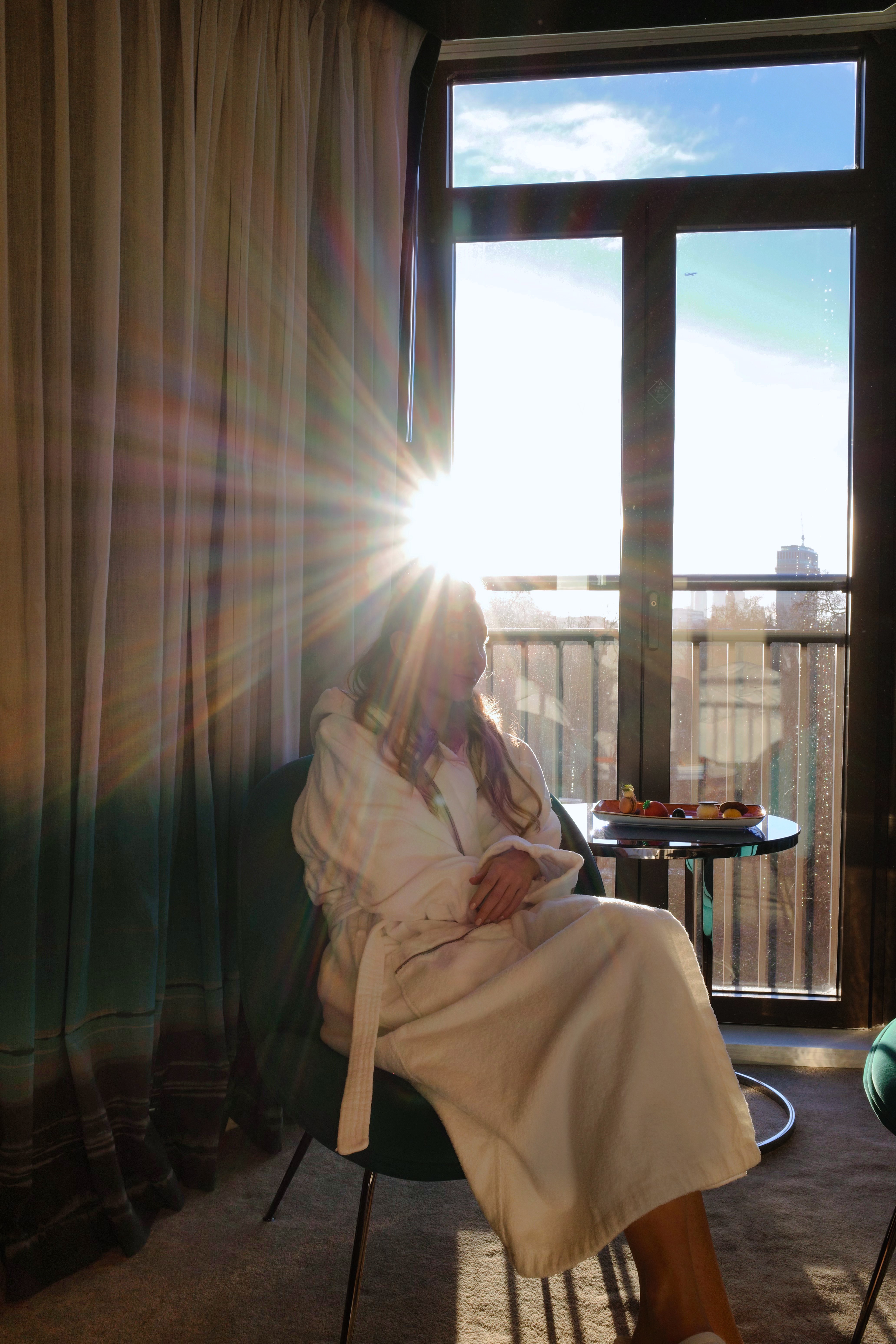 Guest relaxing by the window with a dramatic sun flare