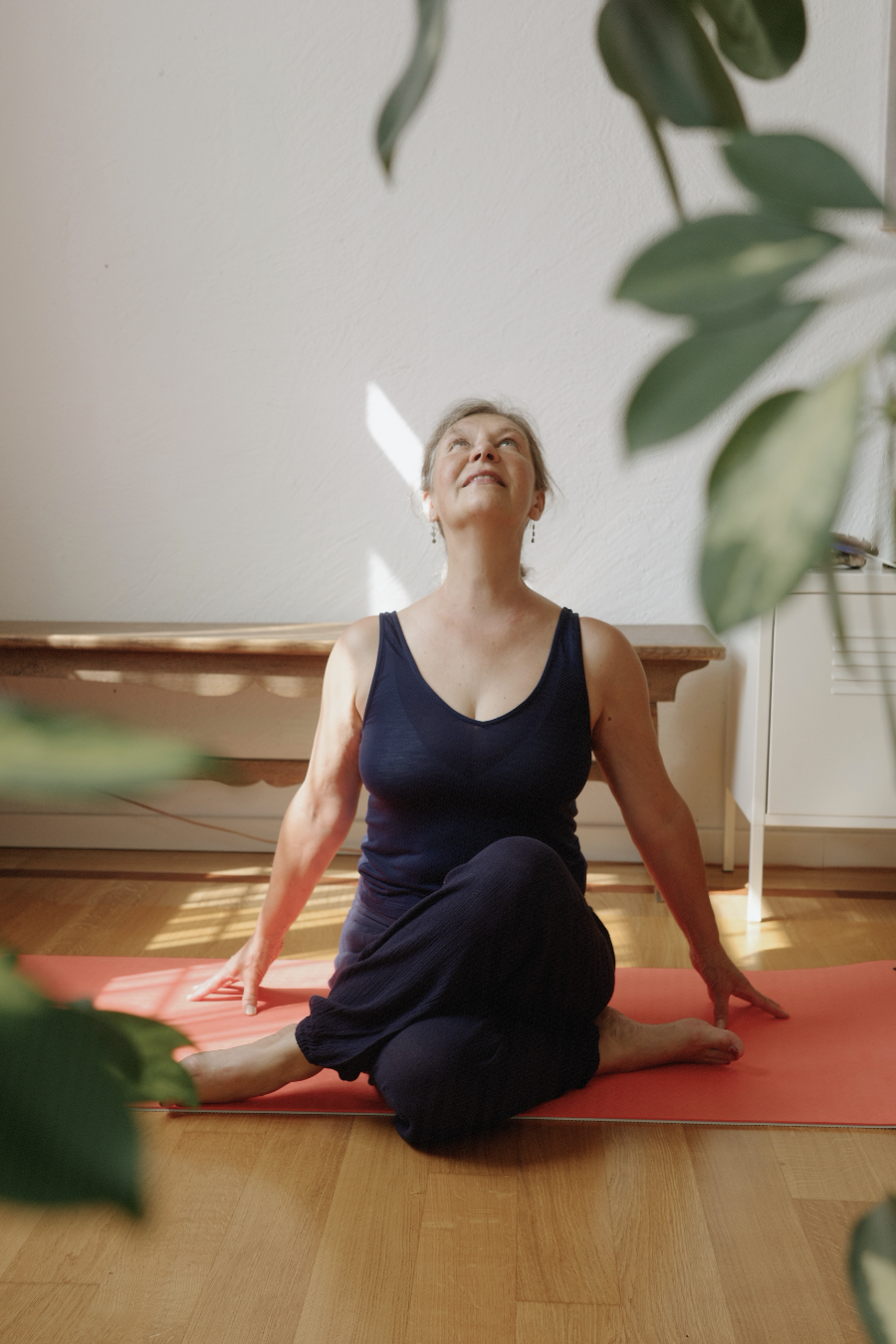 Christina seated on yoga mat looking upward