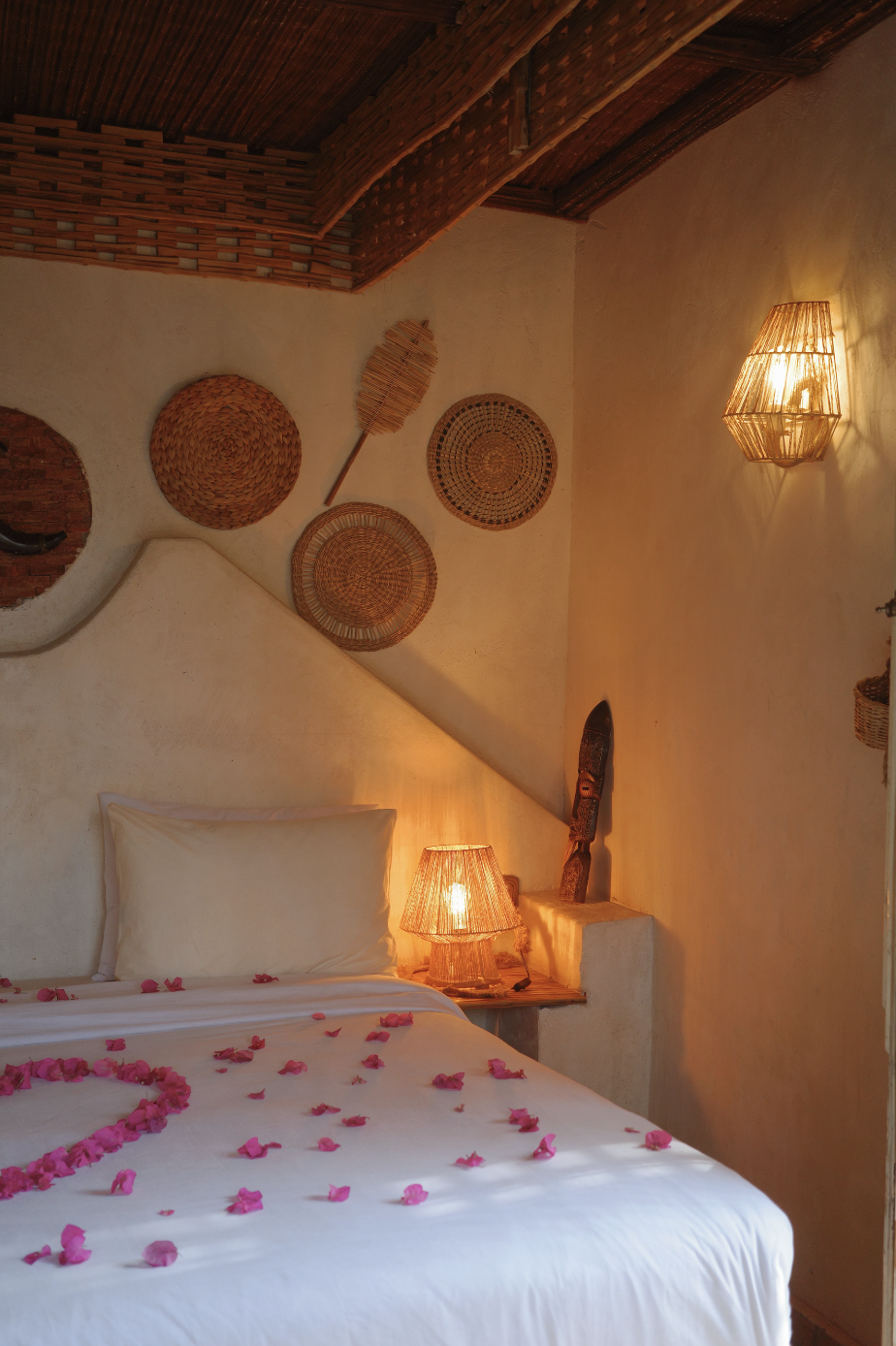 Cozy bedroom with woven basket wall decor and rose petals