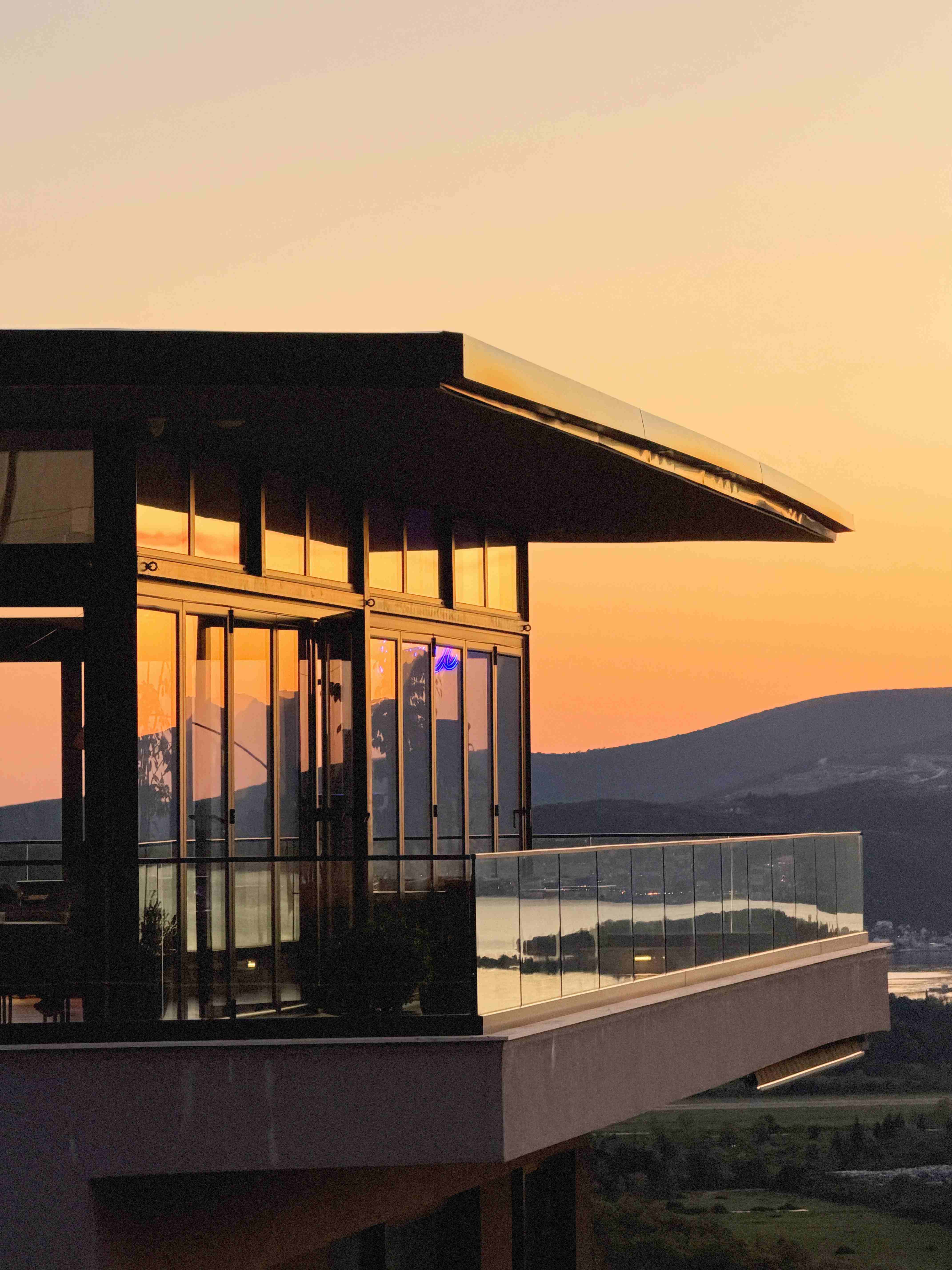 Nomio's modern glass building and cantilevered terrace at sunset