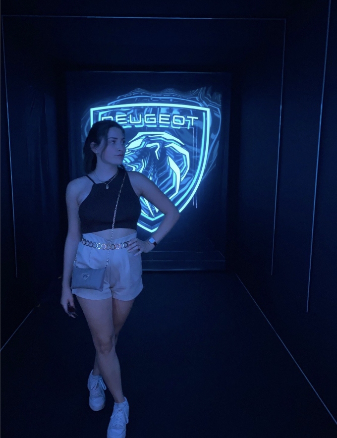 Woman in front of illuminated Peugeot logo